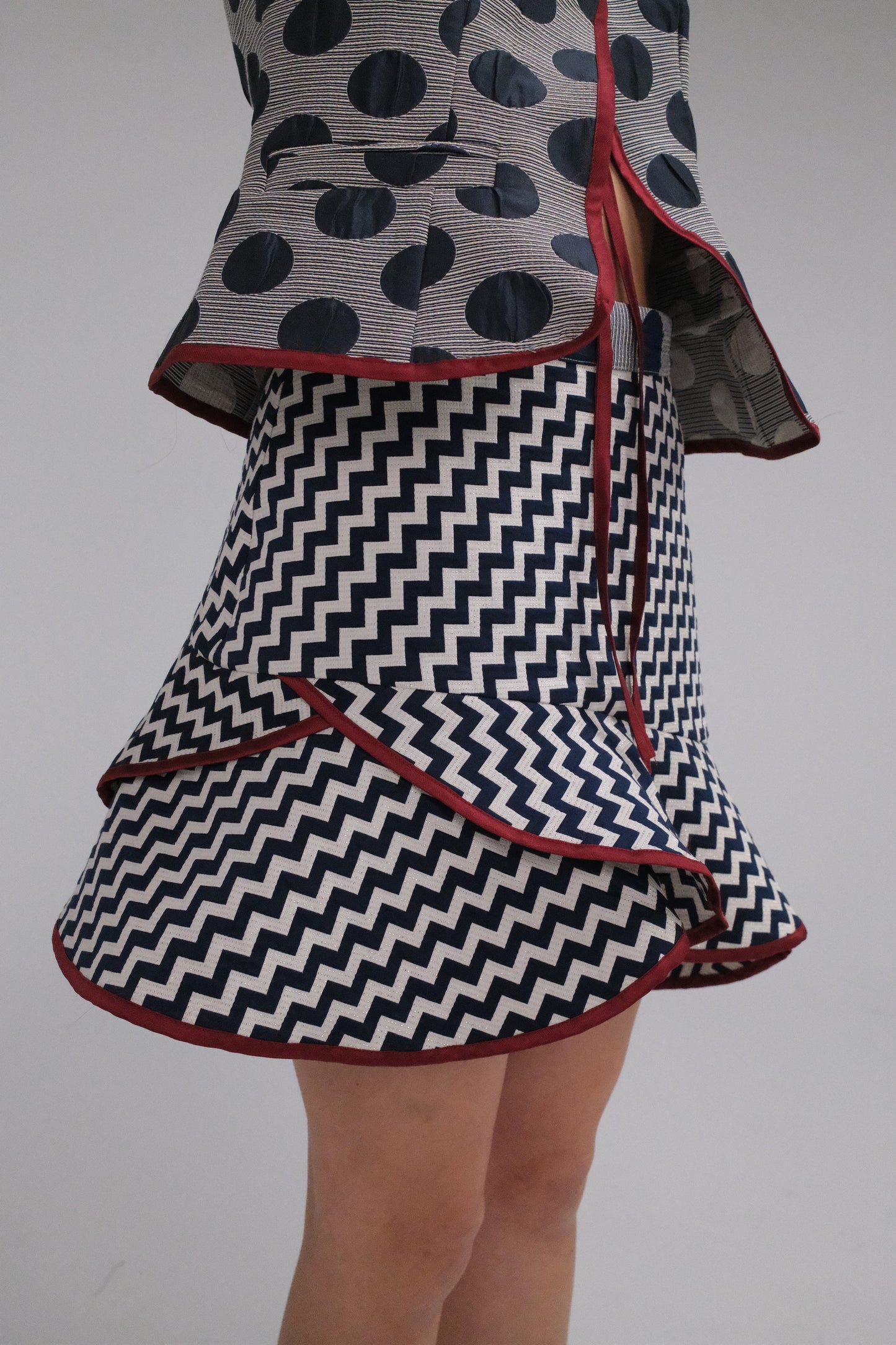 THE ZIGZAG ASYMMETRICAL MINI SKIRT WITH BURGUNDY TRIM