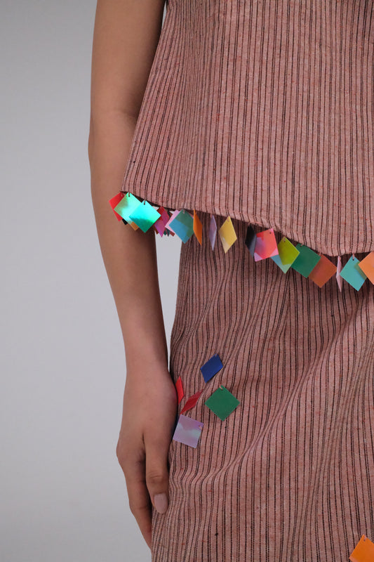 THE LIGHT ORANGE TOP WITH COINS