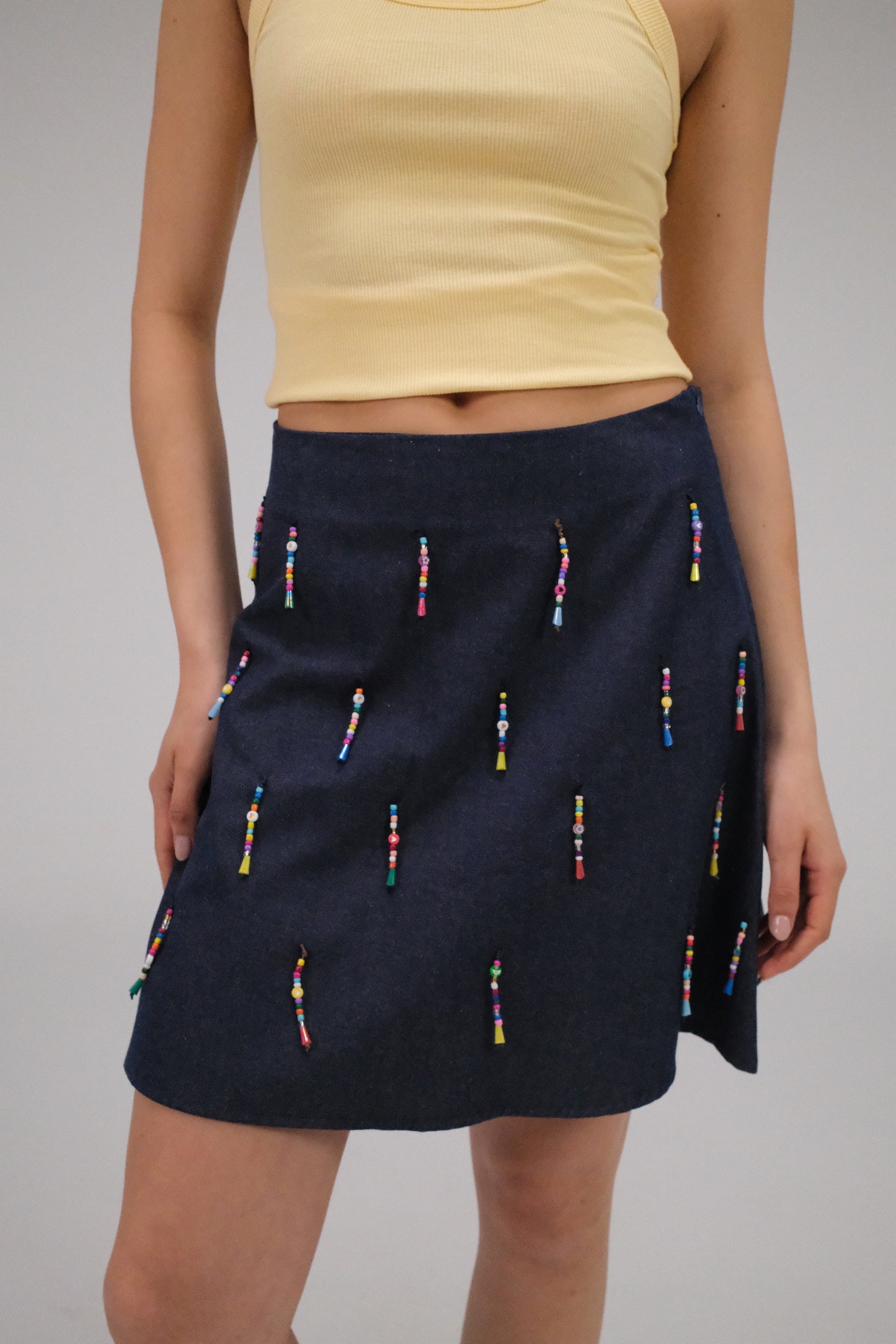 THE DENIM ALINE MINI SKIRT WITH DANGLING BEADS