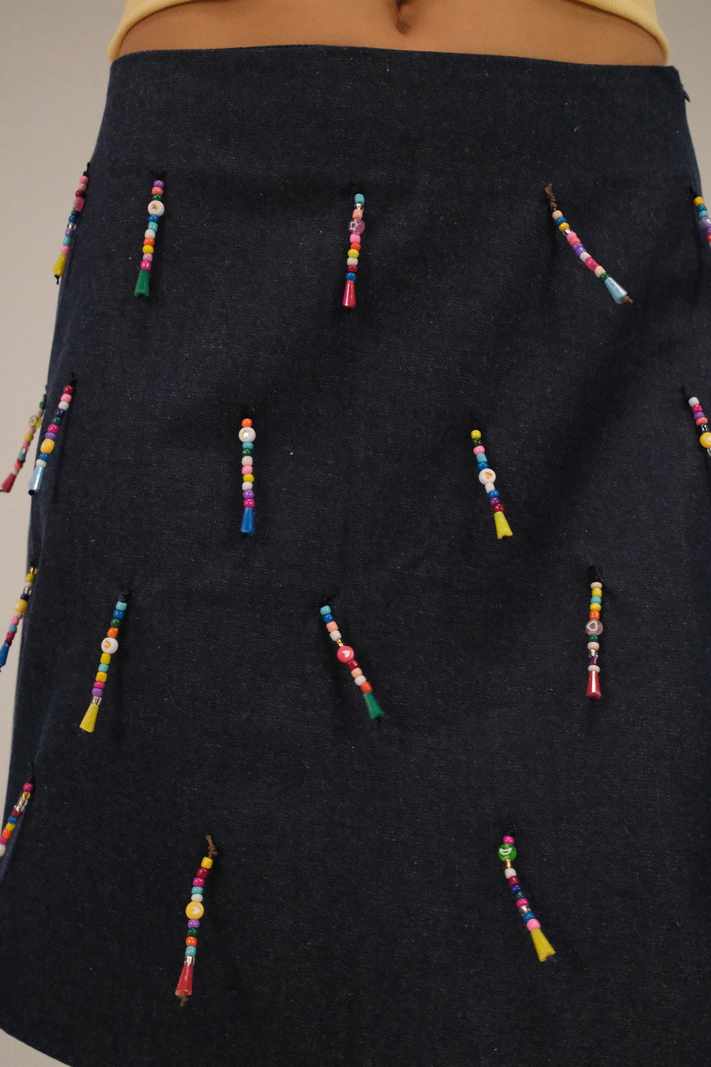 THE DENIM ALINE MINI SKIRT WITH DANGLING BEADS