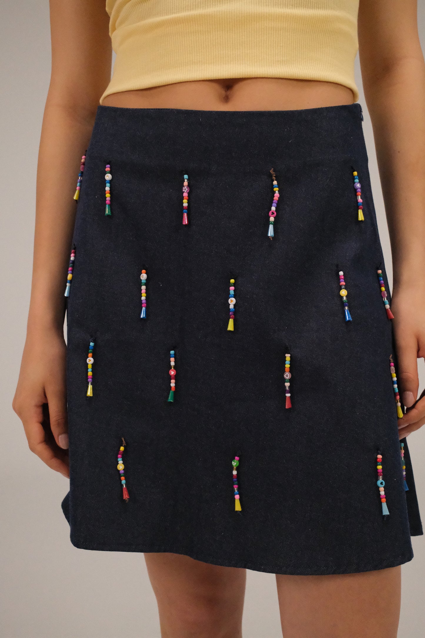 THE DENIM ALINE MINI SKIRT WITH DANGLING BEADS